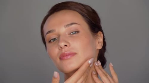 Woman Massaging Face Gently for Skincare Routine
