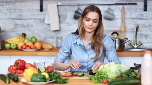 Woman Chopping Vegetables in Bright Kitchen, Looks Tired