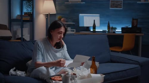 Annoyed Desperate Young Woman Sitting on Sofa Reading Eviction Notice