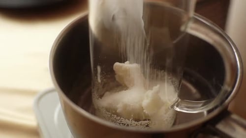 Closeup Hands of Unrecognizable Female Artisan Pouring Dry Ingredient Into Glass Measuring Jar for