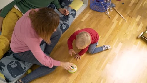 Child Crawling on Floor While Playing With Family
