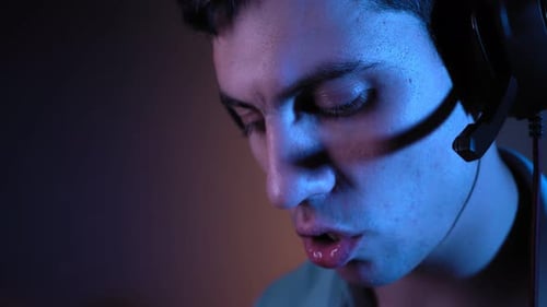 Young Man with Headset Speaking in Blue Lighting