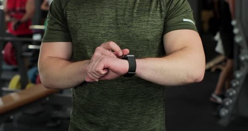 Closeup Handsome Sportsman Checking Results in Fitness Center
