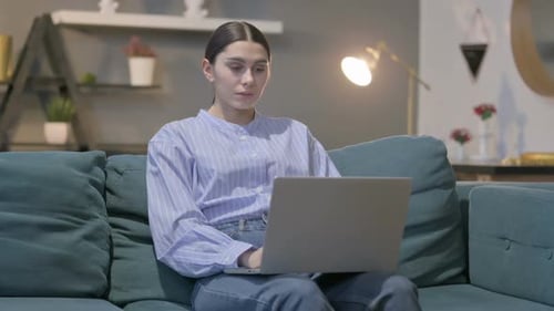 Woman Works on Laptop from Couch at Home