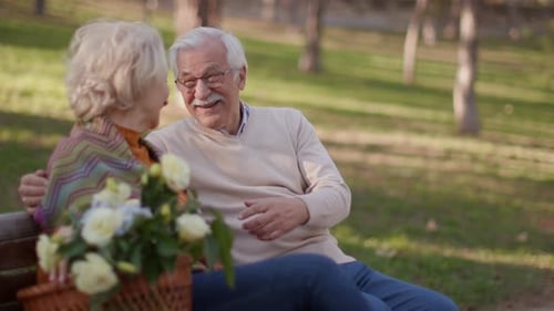 Affectionate Grandparents Embrace Granddaughter in Sunny Park