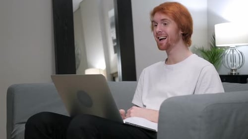 Red-Haired Man Video Calling on Laptop at Home