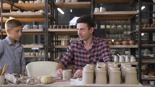 Man and Boy Working on Pottery in Bright Studio