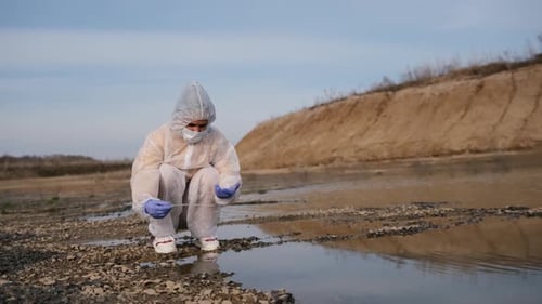 Scientist Examining Water Sample in Rural Landscape