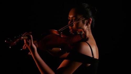 Young Woman Playing Violin in Dramatic Lighting