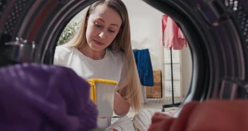 Woman Loading Laundry in Washing Machine, Inside View