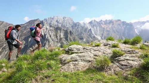 Group Hiking Across Rocky Mountain Peak on Sunny Day