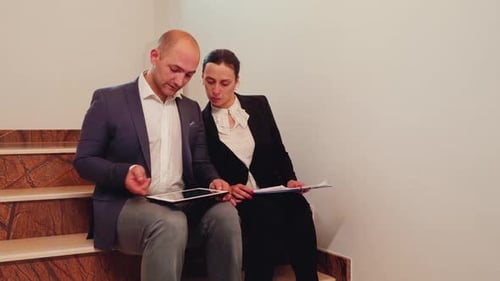 Company Manager Advising Office Executive on Staircase