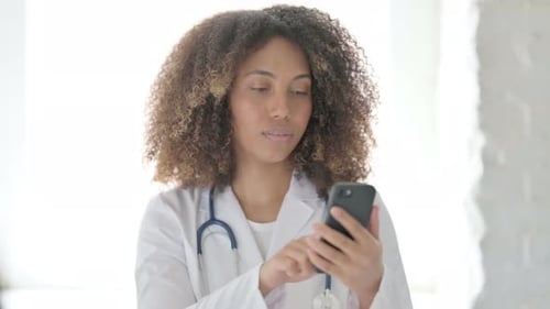 Female Doctor Using Phone, Brightly Lit
