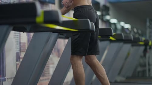 Unrecognizable Fit Sportsman Running on Treadmill in Gym Indoors
