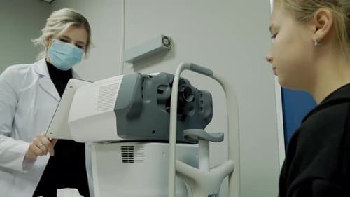 Der Augenarzt untersucht das Auge des Patienten und schaut dann in die Kamera
