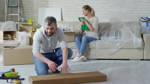Couple Packing and Unpacking Boxes in a New Home