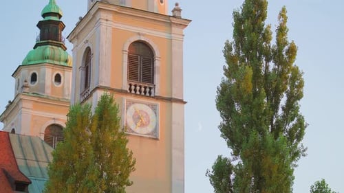 Closeup View of Building with Monograms and Clock on Wall