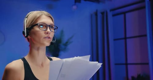 Femme en tenue de sport dans un casque qui parle avec un interlocuteur par micro pendant les documents d'examen