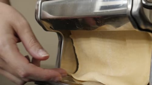 Dough Sheet Through Pasta Machine in Close Up