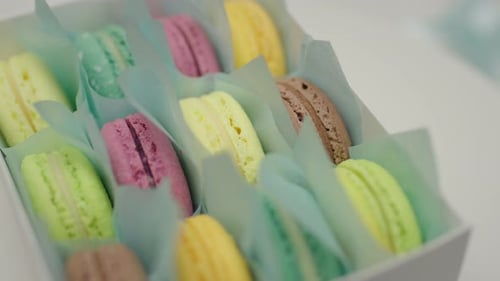 Gift box of color macaron cookies rotating. Close up, slow motion.