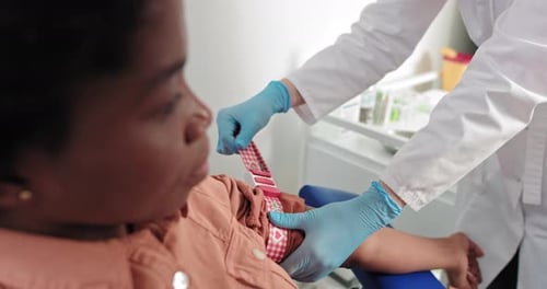 Medical Professional Applying Tourniquet in Clinic