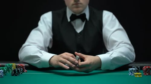 Card Dealer Shuffles Deck at Gaming Table