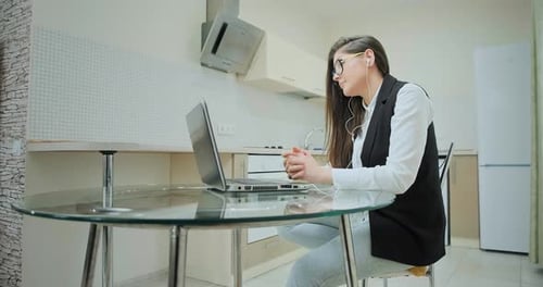 Young Woman Attends Virtual Meeting in Kitchen