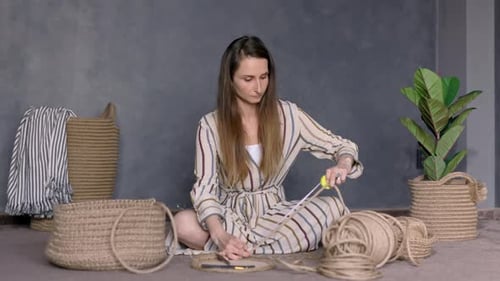 Woman Creates Woven Rope Basket on Rug