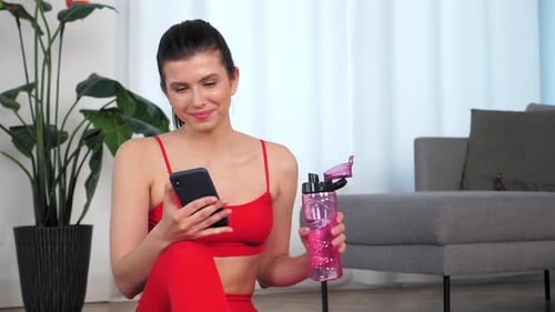 Young Woman Using Phone After Workout