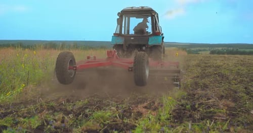 Farmer Works the Land Plows the Field on a Tractor