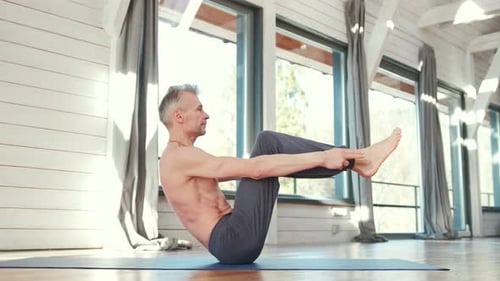 Man Doing Yoga Pose on Mat Indoors
