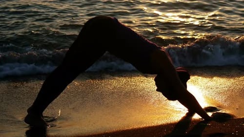 Woman performing yoga on the beach