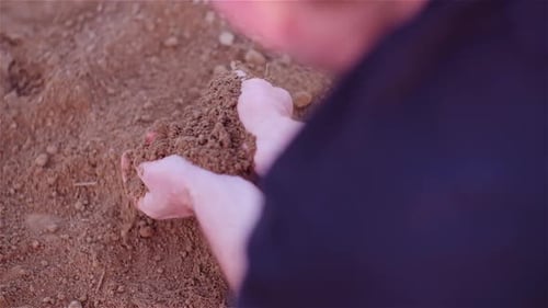 Landwirt untersucht organischen Boden in Händen, Landwirt berührt Schmutz im landwirtschaftlichen Bereich