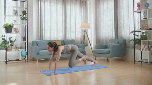 Woman Doing Mountain Climbers on Yoga Mat Indoors