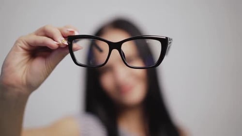 Fashionable eyeglasses close-up on the blurred background of a woman.