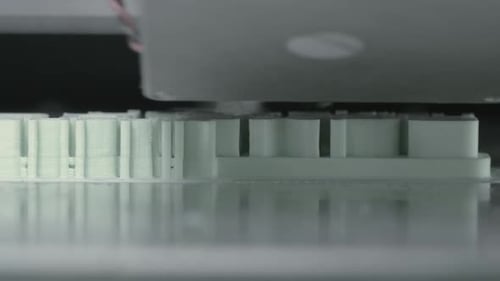 Extreme Nahaufnahme des Mechanismus eines 3D-Druckers, der weiße Kunststoffobjekte herstellt