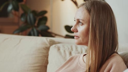 Woman Using Laptop Relaxing on Sofa Indoors