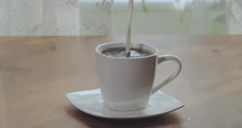 Milk Poured Into Mug of Coffee