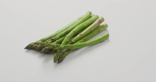 Video of fresh asparagus with copy space over white background