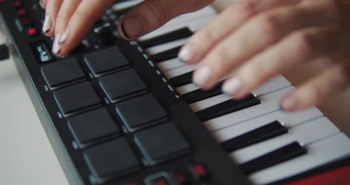 Woman's Hands Playing Small Black and White Keyboard