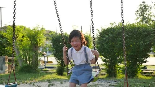 Cute Asian Child Having Fun On Swing In The Park Slow Motion