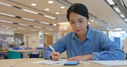 Femme étudie à la bibliothèque