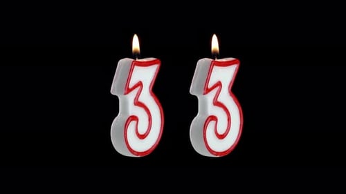 Candle in the Shape of the Number Thirty Three on a Black Background