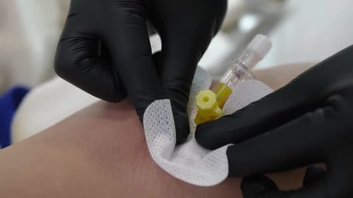 Medical Professional Tending to Patient with IV