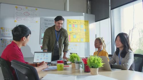 caucasian male designer present new business plan to his team in office