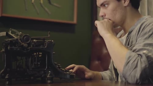 Young Man Typing on an Antique Typewriter