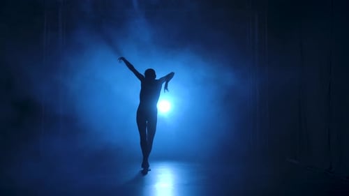 Silhouette of Dancer Performing Gracefully in Blue Light