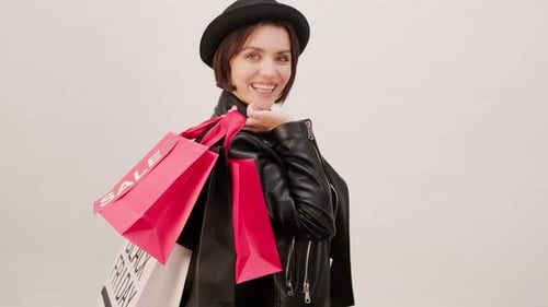 Stylish Woman Smiles with Shopping Bags on Shoulder