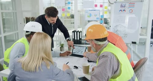 Spezialisten der Bauindustrie halten ein Treffen ab und diskutieren Details des gemeinsamen Bauprojekts
