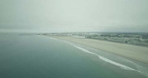 Kamera schwenkt von Häusern am Meer auf Wasser, Helikopter-Luftaufnahme am Tag